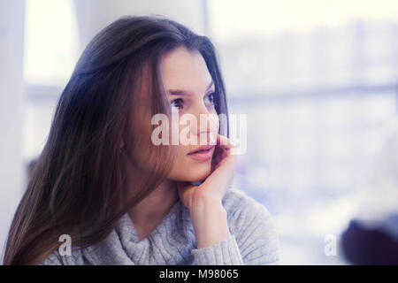 Porträt der jungen Frau mit Kopf in der hand Stockfoto