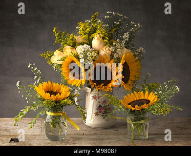 Sonnenblumen in Antike Kanne und Marmelade Gläser Stockfoto