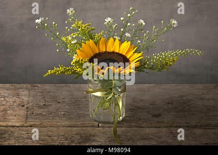 Sonnenblumen in Kaffee Tasse auf hölzernen Tisch Stockfoto