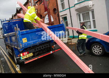 Eine Lieferung mit Holzdach Hölzer von zwei Männern ausgeladen wurde, trug verglastes Jacken, von Händlern bau Lieferanten eine Jewsons Erbauer 'UK Stockfoto