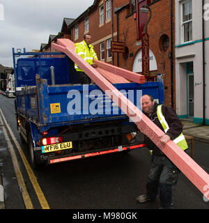 Eine Lieferung mit Holzdach Hölzer von zwei Männern ausgeladen wurde, trug verglastes Jacken, von Händlern bau Lieferanten eine Jewsons Erbauer 'UK Stockfoto