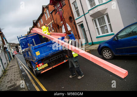 Eine Lieferung mit Holzdach Hölzer von zwei Männern ausgeladen wurde, trug verglastes Jacken, von Händlern bau Lieferanten eine Jewsons Erbauer 'UK Stockfoto