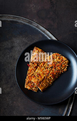 Zwei geraucht und erfahrene Makrelen auf schwarze Platte Stockfoto