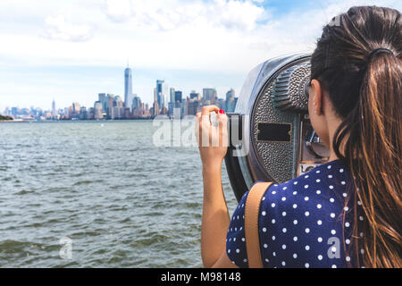 USA, New York, Frau an der Manhattan Skyline mit Münze suchen - Fernglas betrieben Stockfoto