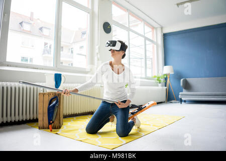 Vital Frau zu Hause tragen VR-Brille wischen den Boden Stockfoto