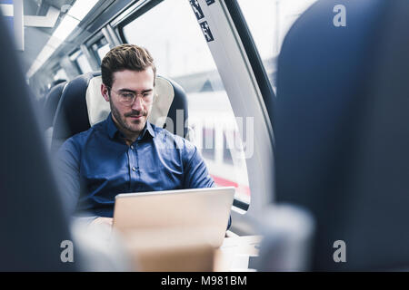 Unternehmer arbeiten in Zug mit Laptop Stockfoto