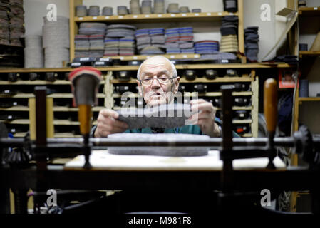 Senior Schuster arbeiten mit altmodischen Stanzmaschine in Werkstatt Stockfoto