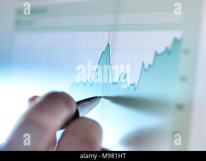 Hand eines Börsenmakler Analyse Line Graph auf Bildschirm Stockfoto