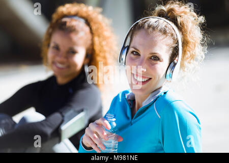 Portrait von zwei lächelnde sportliche junge Frauen mit einer Unterbrechung Stockfoto