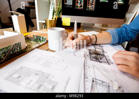 Junge Frau, die in der Architektur Büro, zeichnen Baupläne Stockfoto