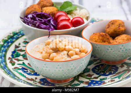 Hummus, Süßkartoffel-Kugeln, Couscous und Gemüse in Schalen Stockfoto