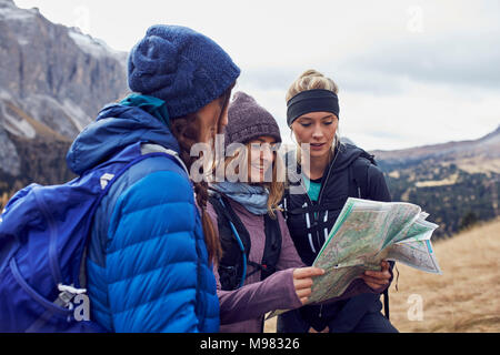 Drei junge Frauen wandern in den Bergen und auf der Karte suchen Stockfoto