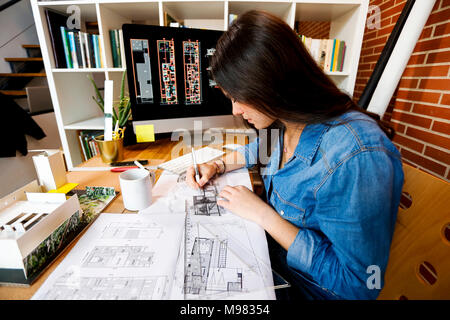 Junge Frau, die in der Architektur Büro, zeichnen Baupläne Stockfoto