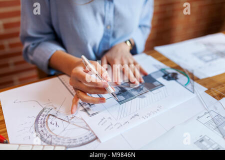 Junge Frau, die in der Architektur Büro, zeichnen Baupläne Stockfoto