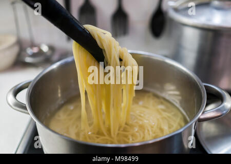 Die Spaghetti in einem großen Topf mit kochendem Wasser zubereitet. Mittagessen für die ganze Familie. Stockfoto