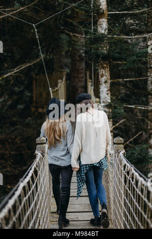 Zwei glückliche junge Frauen gehen auf eine Suspension zusammen Stockfoto