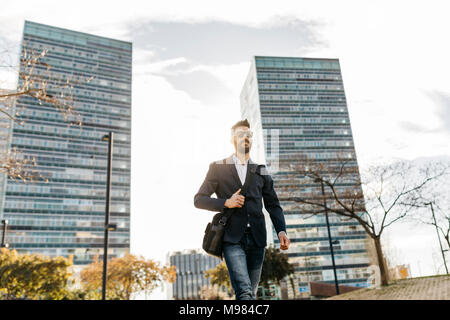 Unternehmer tragen Sonnenbrillen zu Fuß außerhalb der Gebäude Stockfoto