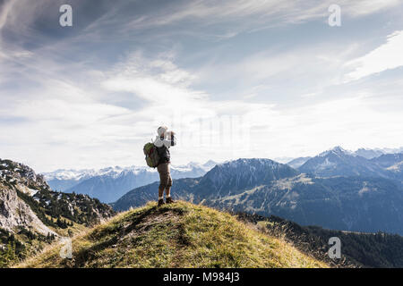 Österreich, Tirol, junger Mann, der Bergwelt in Aussicht mit dem Fernglas suchen Stockfoto