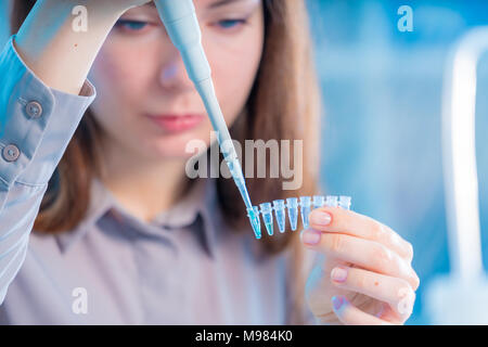 Technikerin mit Pipette in Kop für DNA die gerichtliche Prüfung Stockfoto