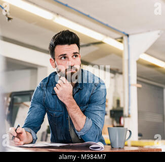 Man schaut vom Entwurf in der Werkstatt Stockfoto