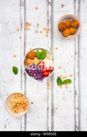 Süßkartoffel-Kugeln, Couscous, Hummus und Gemüse in Schalen Stockfoto