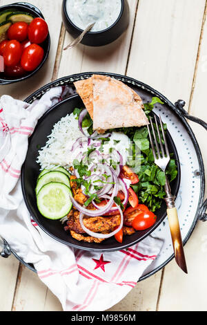 Gyros, Reis, Huhn, Salat, Tomaten, Gurken, Zwiebel, Tzatziki, hausgemachtem Fladenbrot Stockfoto