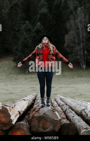 Junge Frau Balancieren auf Protokolle Stockfoto