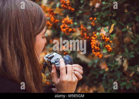 Junge Frau die Bilder mit alten Kamera in der herbstlichen Natur Stockfoto