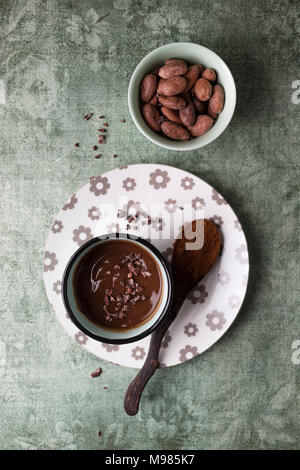 Tasse Schokoladenpudding mit Kakao, Kakao Nibs und Kakaobohnen Stockfoto