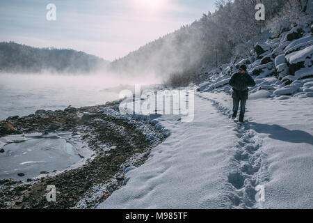 Russland, Amur Oblast, Mann am Flußufer der Bureya in der verschneiten Natur Stockfoto