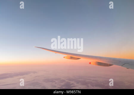 Europa, Flügel eines Flugzeugs mit Wolken bei Sonnenaufgang Stockfoto