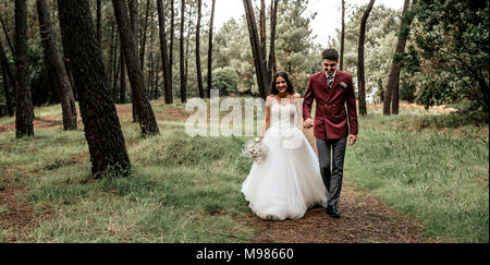Glückliche Braut und Bräutigam walking im Wald Stockfoto
