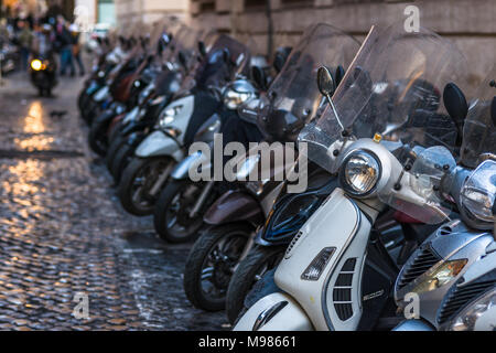 Vespas und andere Motorräder auf gepflasterten Straßen von Rom, Latium, Italien. Stockfoto