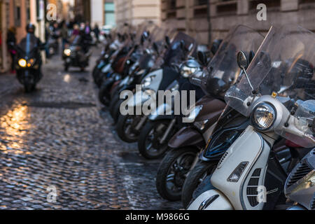 Vespas und andere Motorräder auf gepflasterten Straßen von Rom, Latium, Italien. Stockfoto