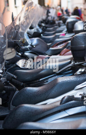 Vespas und andere Motorräder auf gepflasterten Straßen von Rom, Latium, Italien. Stockfoto