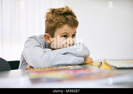 Grinsend Schüler lehnen auf Schreibtisch in der Klasse Stockfoto