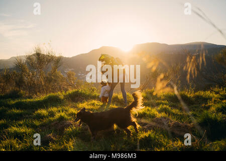 Spanien, Barcelona, Oma mit Enkelin und Hund während einer Wanderung bei Sonnenuntergang Stockfoto