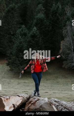 Junge Frau Balancieren auf Protokolle Stockfoto