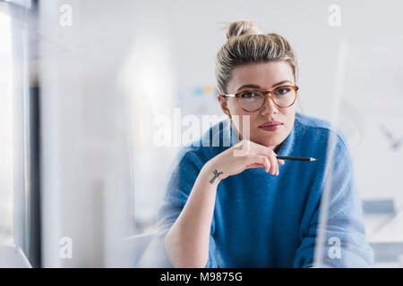 Porträt der jungen Frau mit Brille im Büro Stockfoto