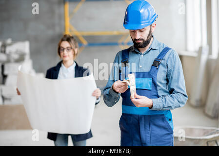 Builder zählen Geld Stockfoto