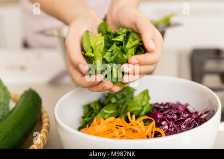 Hände, frischem Salat in eine Schüssel mit verschiedenen Gemüsen Stockfoto