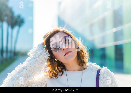 Porträt der jungen Frau mit Sonnenbrille im Freien Stockfoto