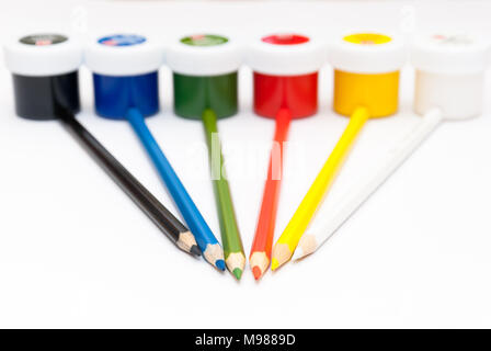 Sechs Buntstifte Lüge gegen Gläser mit Gouache Stockfoto