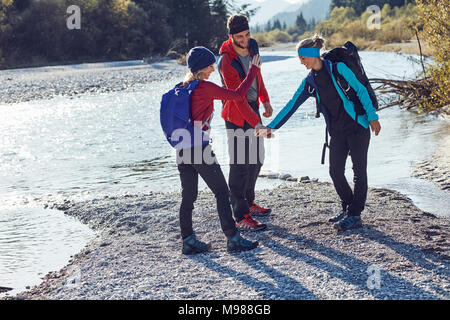 Gruppe von Freunden wandern die Hände schütteln am Flußufer Stockfoto