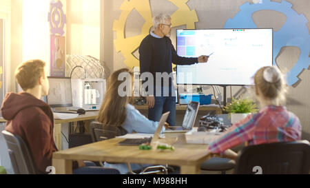 Die Lehrerin arbeitet mit Jungen und Mädchen in einem Computer Wissenschaft Kategorie. Kinder nutzen Laptops. Stockfoto