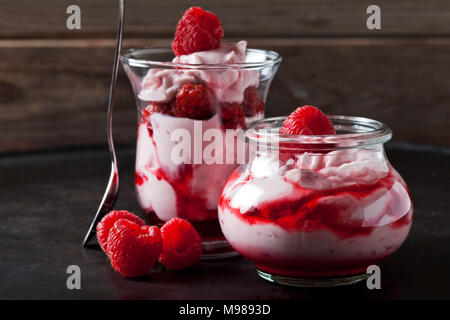 Kleinigkeit von Schlagsahne mit Erdbeeren und Erdbeersauce in Gläsern Stockfoto