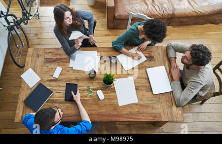 Ansicht von Kollegen zusammen an den hölzernen Tisch arbeiten im Büro Stockfoto