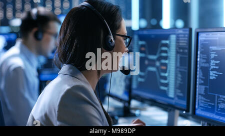 Im System Control Center Frau arbeiten in einem Team für die technische Unterstützung gibt Anweisungen mit Hilfe des Headsets. Möglich Air Traffic Stockfoto