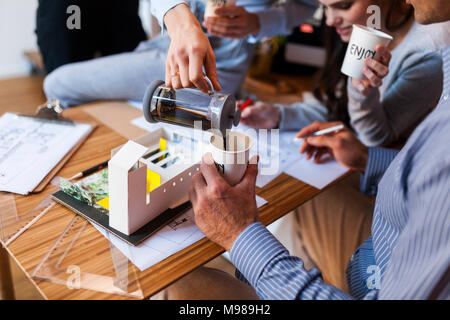 Team von Architekten, die an einem Projekt arbeitet, trinken Kaffee Stockfoto