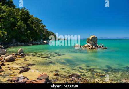 Neuseeland, Südinsel, Abel Tasman National Park, Touristen auf Felsen im Meer Stockfoto